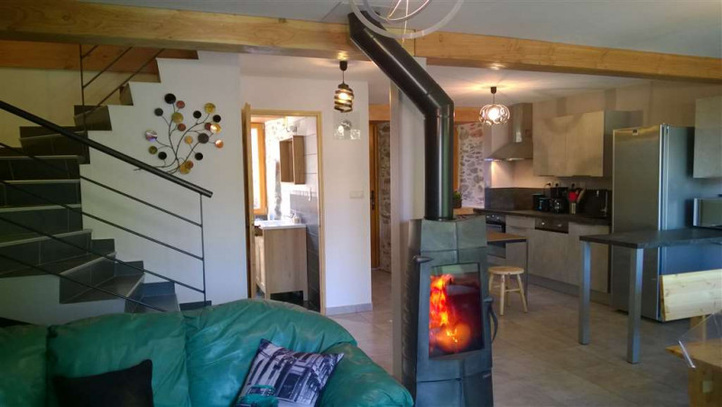 Espace cuisine ouvert sur le salon avec poêle-cheminée Espace cuisine ouvert sur le salon avec poêle-cheminée